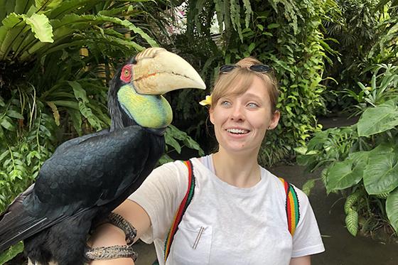 Photo of a 冰球突破app student in a jungle with a large exotic bird perched on her arm