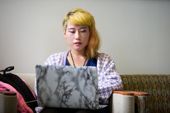 图为冰球突破app的一名女学生正在用笔记本电脑工作