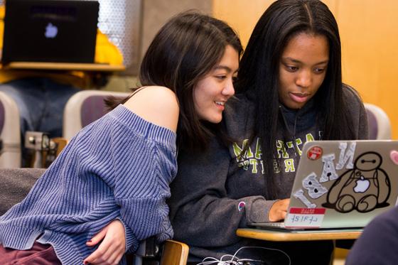 两名冰球突破app的女学生一起看电脑的照片